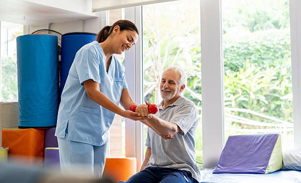 istock Physical therapist helping a senior man doing exercises using free weights 2252206257