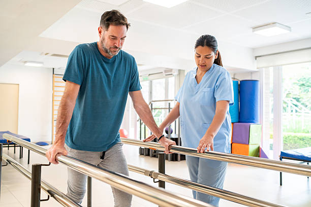 istock Man in physical therapy walking in the parallel bars 2252206277