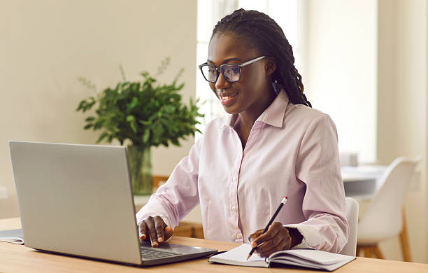 istock Happy African American woman studying online, using laptop and writing in notebook 2252206467