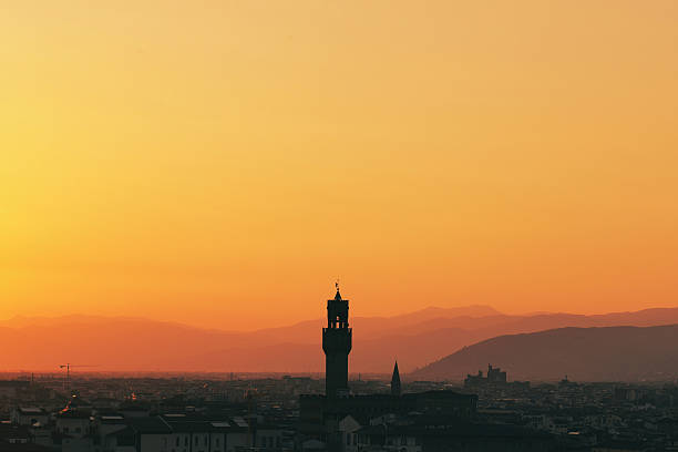 Vibrant Sunset Over Historic Florence Skyline with Iconic Ponte Vecchio Bridge Reflecting on Arno River Against Distant Mountains
