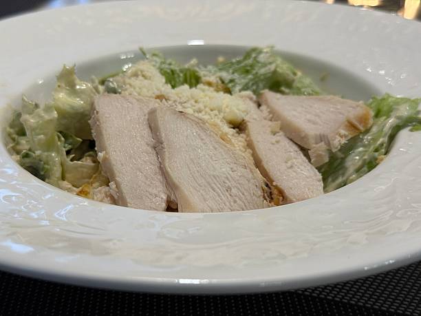 istock Caesar salad with grilled chicken and parmesan on elegant white plate 2252210594