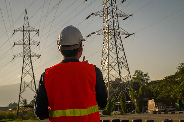 istock Male Engineer Silhouette Inspecting Power Lines and Electricity Pylon 2252210747