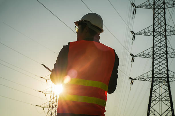 istock Male Engineer Silhouette Inspecting Power Lines and Electricity Pylon 2252210761