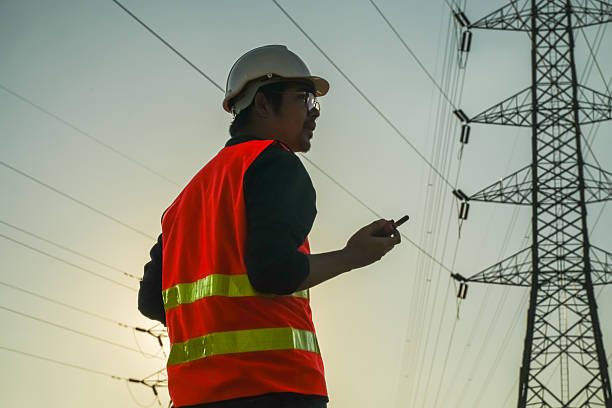 istock Male Engineer Silhouette Inspecting Power Lines and Electricity Pylon 2252210771