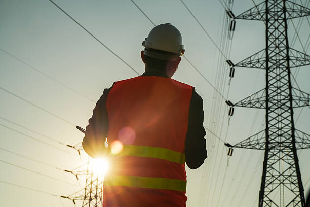 istock Male Engineer Silhouette Inspecting Power Lines and Electricity Pylon 2252210772