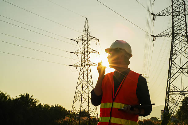 istock High Voltage Tower and Power Lines with Engineer Silhouette at Golden Hour 2252210812