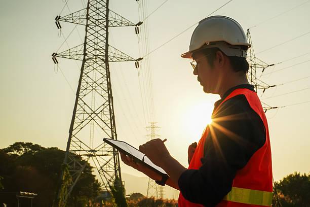 istock High Voltage Tower and Power Lines with Engineer Silhouette at Golden Hour 2252210821