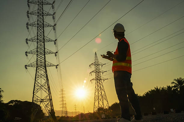 istock High Voltage Tower and Power Lines with Engineer Silhouette at Golden Hour 2252210840