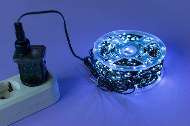 istock Coiled LED Strip Light Connected to Power Source on Purple Background 2252213936