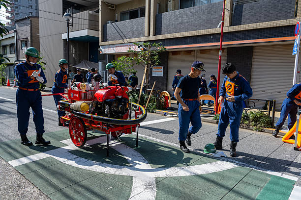 Firefighters in the middle of a residential area in Bunkyo district in Tokyo conduct a fire drill on October 5, 2025