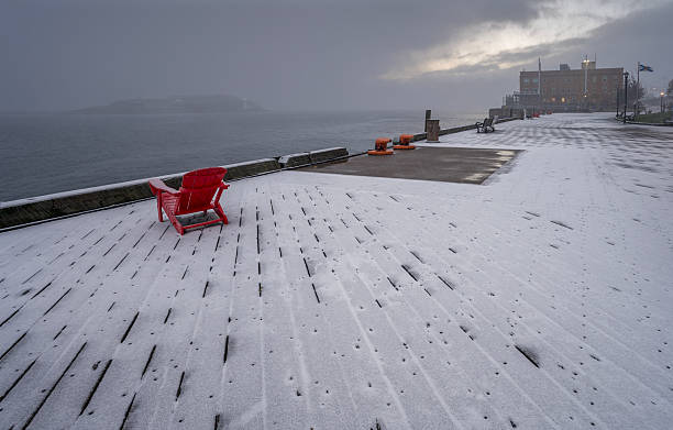 Chair on snow covered boardwalk on the waterfront at Halifax, Nova Scotia, Canada