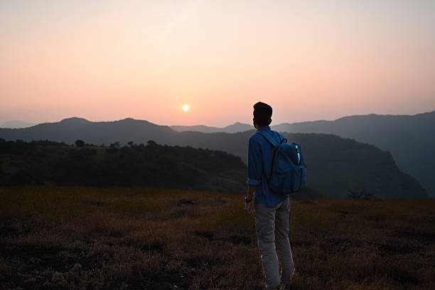 istock Man with Backpack Watching Sunrise Over Mountain Landscape 2252216751