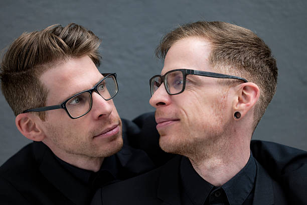 istock Twin Brothers Wearing Glasses Looking at Each Other 2252216922