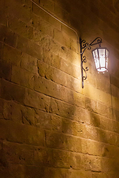 istock Classic Iron Lantern on a Stone Wall Illuminating a Quiet Night Scene 2252221373