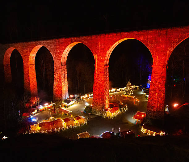 istock Illuminated stone viaduct with Christmas market under arches at night 2252232994