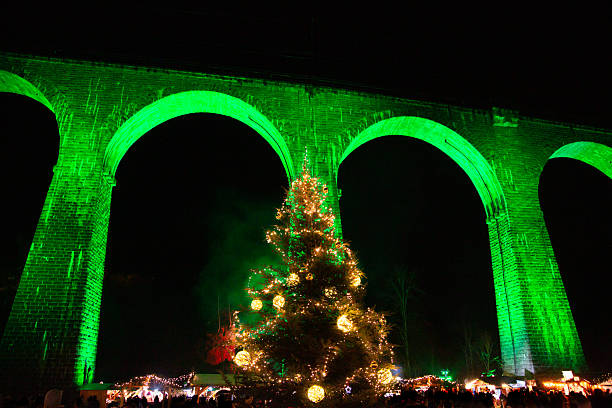 istock Christmas tree under illuminated green brick viaduct at night 2252233034
