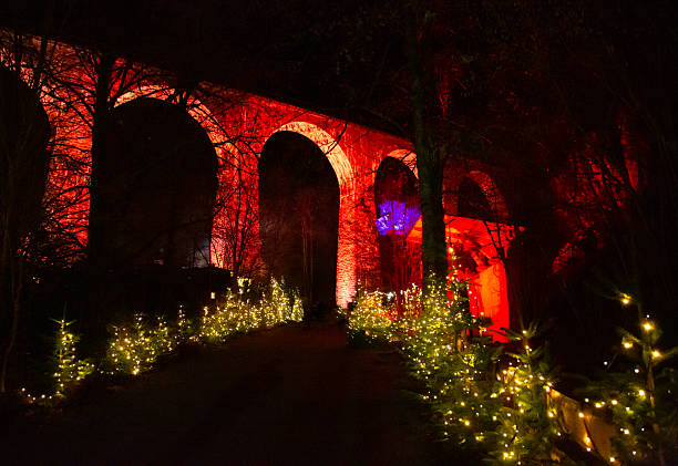 Illuminated historic brick viaduct with Christmas lights at night