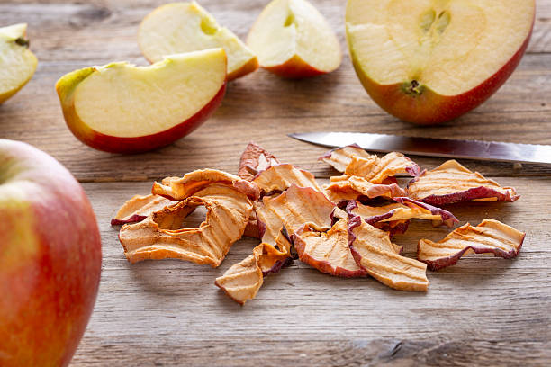 Organic apple cinnamon chips (slices) over rustic wooden background with copy space - healthy vegan vegetarian fruit snack or ingredient for cooking