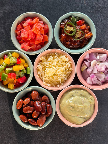 istock Image of assorted mixed dips and side dishes served with fajitas and nachos, featuring chopped peppers, salsa, cheese, beans, onions, and guacamole 2252234064