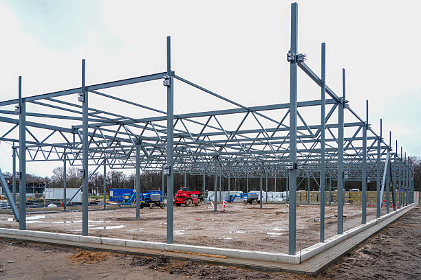 istock Steel warehouse frame under construction with machinery and materials on industrial building site 2252236529
