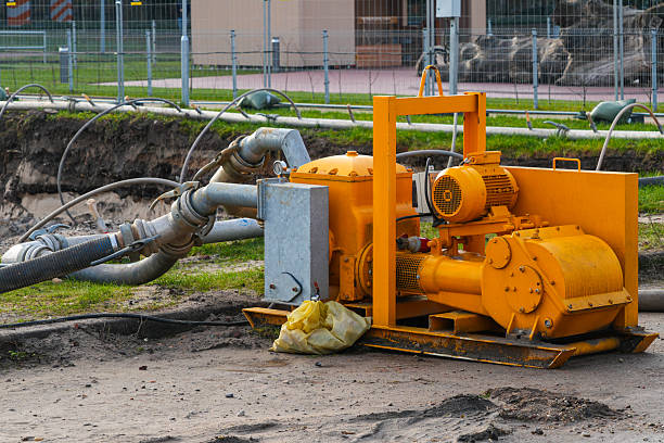 istock Industrial dewatering pump with hoses operating at construction site for groundwater removal 2252237561