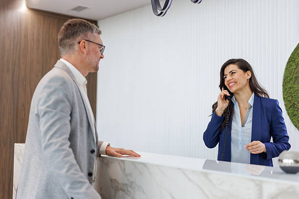 istock Business man interacting with smiling receptionist at front desk 2252237614