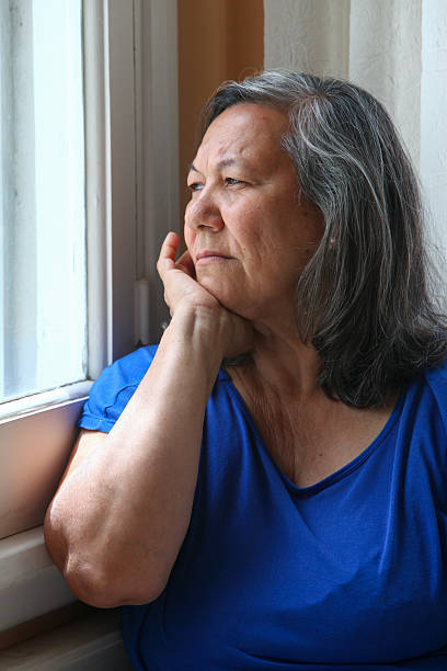 istock Thoughtful senior woman looking out a window, 2252238562
