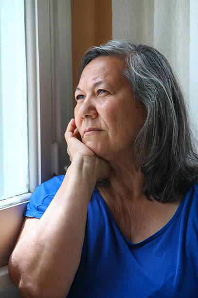 istock Thoughtful senior woman looking out a window, 2252238567