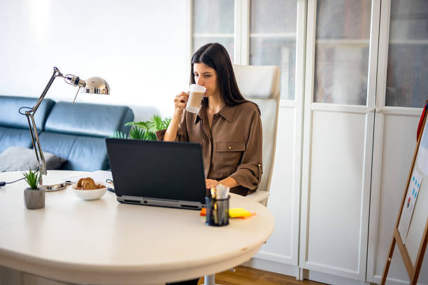 istock Young business woman works and drinks coffee 2252238749