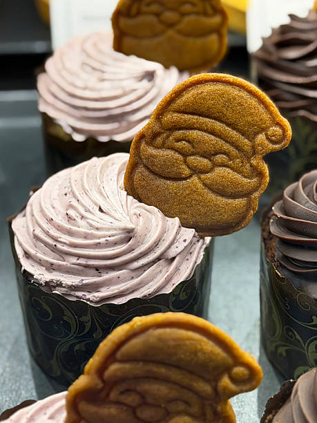 Image of santa-themed christmas cupcakes and muffins with gingerbread cookies, biscuits, tree-shaped moulds, butter, and icing cream