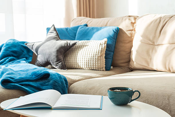 istock Festive Living Room with Cushions, Blue Blanket, Mug, and Open Book 2252240996