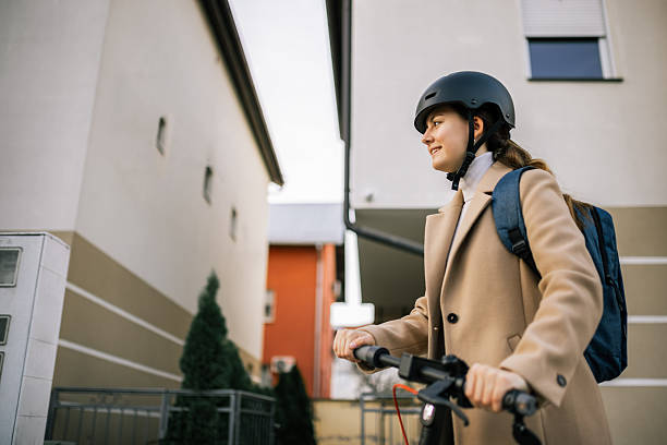 istock Girl rides electric scooter with helmet and backpack 2252253362