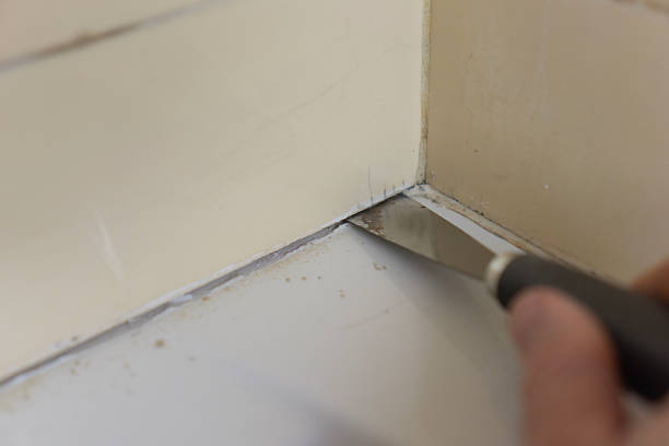 istock hands cleaning tile joints with metal spatula tool before grouting in bathroom or kitchen with copy space for banner design concept of home renovation repair construction 2252254425