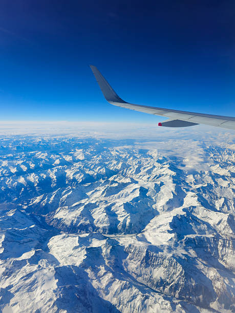 istock Airplane wing flying over snow covered alps mountain range 2252256107