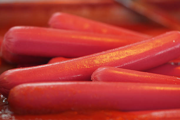 istock Colorful hot dogs piled on a red surface ready for grilling 2252256789