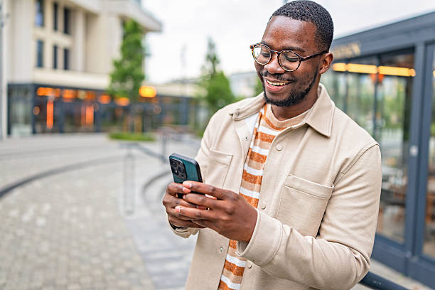 istock Man enjoying outdoor activity while using smartphone in a lively urban setting during daytime hours 2252259646