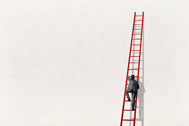 istock Man Climbs Ladder Leaning Against A Wall 2252259873