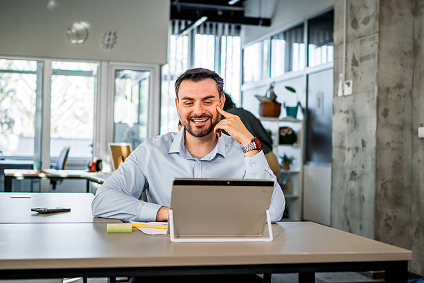 istock Happy businessman having video call on tablet in office 2252260414
