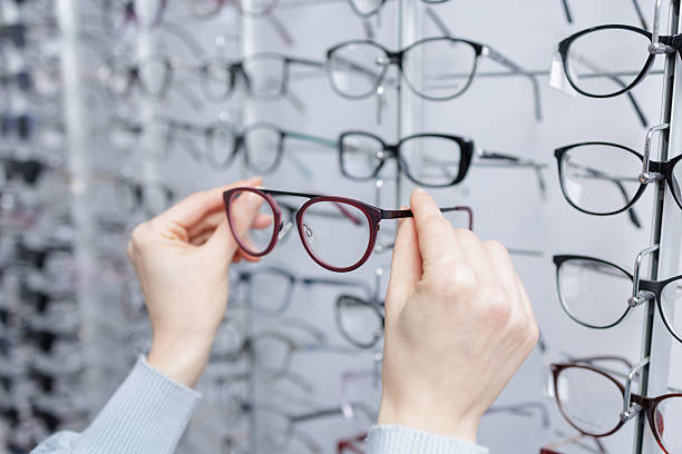 istock Hands choosing eyeglass frames at optician store eyewear shopping and vision care 2252262776