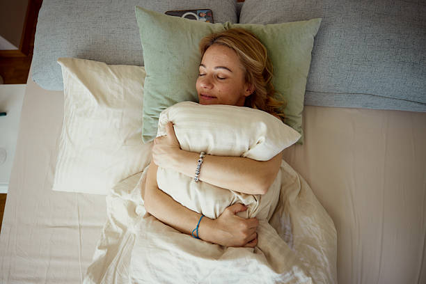 istock Woman sleeping soundly in bed with pillow. 2252266242