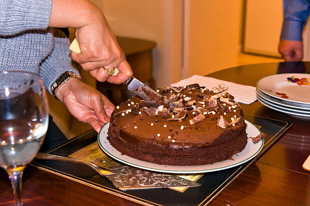 istock Woman's hands cutting a chocolate birthday cake 2252270925
