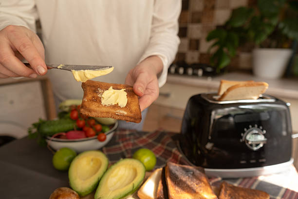 istock Woman uses toaster for quick breakfast preparation modern minimalist kitchen routine with focus on simplicity and convenience. 2252275585