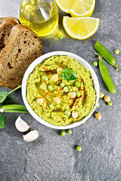 istock Hummus from green peas in bowl with bread on granite table top 2252276367