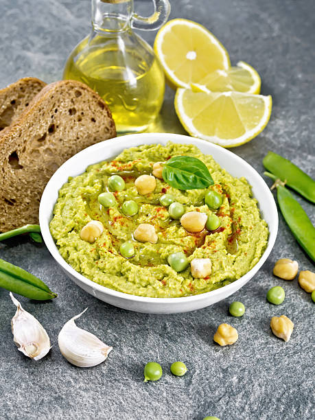 istock Hummus from green peas in bowl with bread on table 2252276370