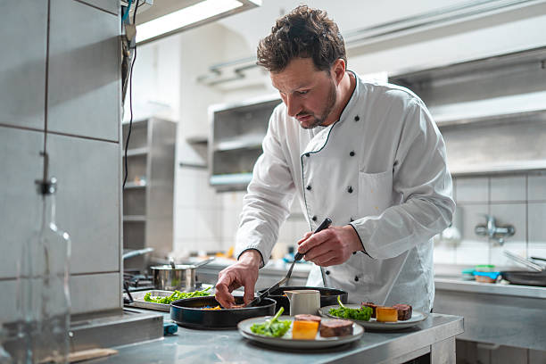 istock Professional Chef Plating Gourmet Dishes in Modern Industrial Kitchen Setting 2252276588