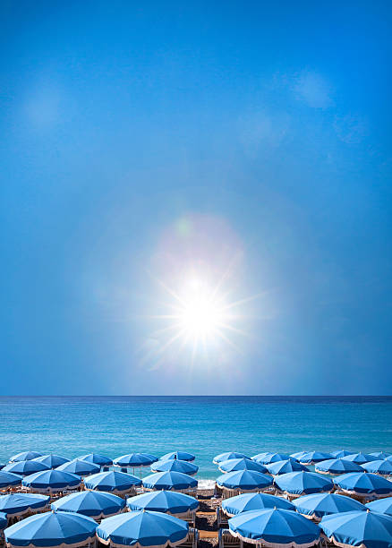 France Nice , beach scene umbrellas for rent Mediterranean sea   sunburst