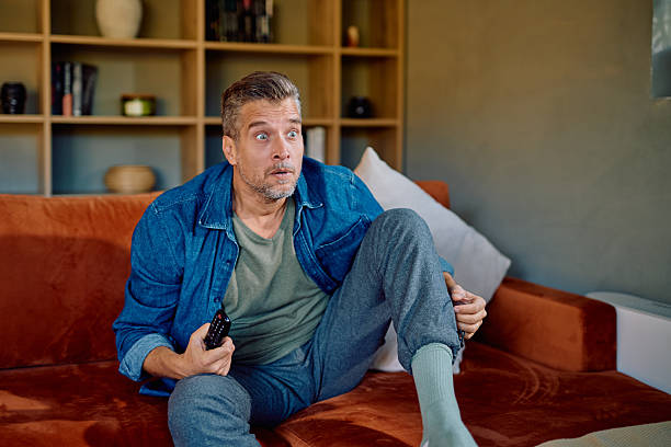 istock Mature man watching TV feeling shocked and surprised 2252276911