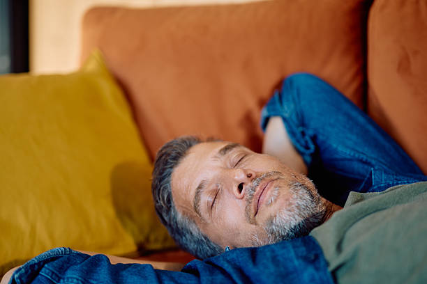 istock Mature adult man relaxing while sleeping on couch 2252277084