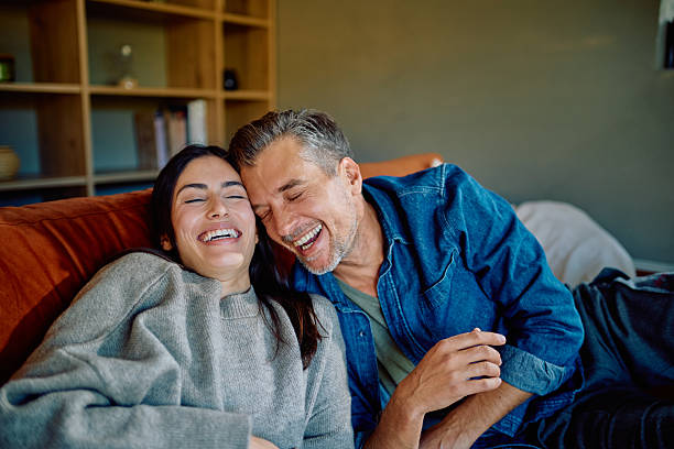 istock Happy couple laughing together relaxing on sofa at home 2252277308