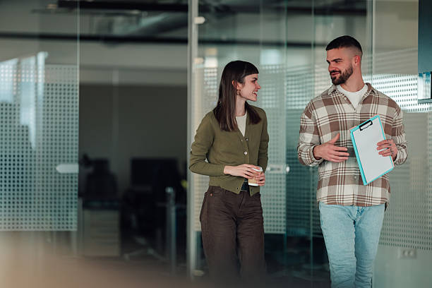 istock Coworkers having conversation walking through modern office 2252278247